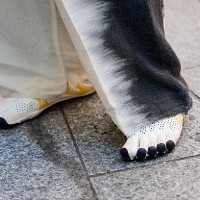 Guest wears white tabi sneakers, outside Kartik Research, during the Menswear Spring/Summer 2026 show as part of Paris Fashion Week on June 29, 2025...