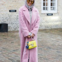 Guest wears yellow Louis Vuitton bag, pink coat, grey hoody outside Munthe during the Copenhagen Fashion Week Autumn/Winter 2025 on January 30, 2025...