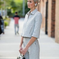 Guest with short hair cut wears grey jacket, pants, black bag outside Tory Burch during New York Fashion Week on September 09, 2024 in New York City.