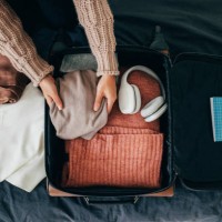 hände einer anonymen frau packen ihren koffer für den winterurlaub, eine overhead-ansicht - travel stock-fotos und bilder