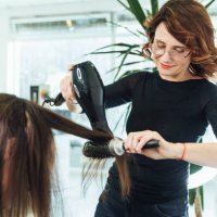 hair drying and combing female customer hair. stylish hairdresser cutting and drying woman hair in salon - hairstyle stock pictures, royalty-free photos & images