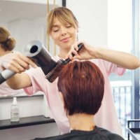 hairstylist working with client hairs with hairdryer - hairstyle stockfoto's en -beelden