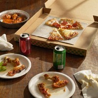 half-eaten pizza , buffalo wings and sodas - junk food stockfoto's en -beelden