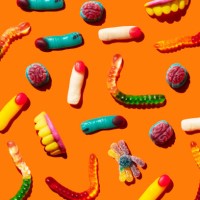 halloween jelly beans, finger-shaped, brains, worm and vampire teeth on orange background - junk food stock pictures, royalty-free photos & images
