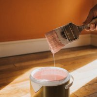 hand dipping a paint brush into a large tin of pink paint as it drips back into the pot - home decoration stock pictures, royalty-free photos & images