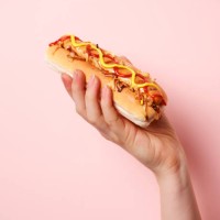 hand holding hotdog - junk food stock pictures, royalty-free photos & images