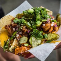 hand holding loaded nachos - junk food stock pictures, royalty-free photos & images