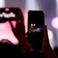 hand holding modern smartphone on a concert. - concert stock pictures, royalty-free photos & images