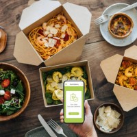 hand holding smartphone, takeaway food on dining table - junk food stock pictures, royalty-free photos & images