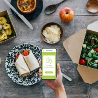 hand holding smartphone, vegetarian takeaway food on dining table - junk food stock pictures, royalty-free photos & images