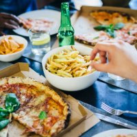 hand reaching for french fries on table - junk food stock pictures, royalty-free photos & images