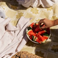 hand reaching for watermelon in bowl - food stock pictures, royalty-free photos & images
