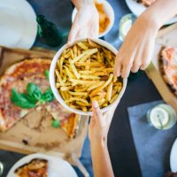 hand taking french fries from bowl - junk food stock pictures, royalty-free photos & images