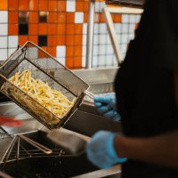 hands, fries and fast food kitchen worker at fryer with gloves, cooking and order process at small business. restaurant chain, working and cook preparing chips for lunch service with hospitality. - junk food stock pictures, r