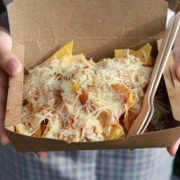 hands holding a take away paper box of nachos with cheese - junk food stock pictures, royalty-free photos & images