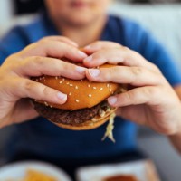 hands is holding a fresh burger before eating - junk food stock pictures, royalty-free photos & images