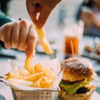 hands of two young people sharing bowl of french fries - food stock pictures, royalty-free photos & images