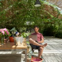 handsome blue eyes man working relaxed on his computer in the garden. - garden decoration stock pictures, royalty-free photos & images
