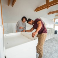 handsome latin american couple organizing a baby room - home decoration stock pictures, royalty-free photos & images