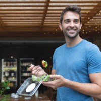 handsome man eating a salad on the go - junk food stock pictures, royalty-free photos & images