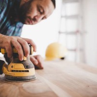 handyman sanding a wood table. - home decoration stock pictures, royalty-free photos & images