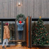 hanging a christmas wreath - garden decoration stock pictures, royalty-free photos & images