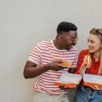 hanging out and eating hot dog with a friend outdoors - junk food stock pictures, royalty-free photos & images