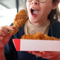 happiness woman holding a paper box with pieces of fried chicken before eating. - junk food stock pictures, royalty-free photos & images