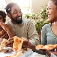happy african american family communicating while having pizza for lunch at home. - junk food stock pictures, royalty-free photos & images