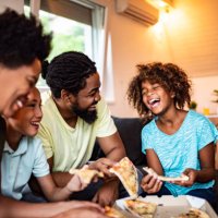happy african american family eating pizza at home. - junk food stock pictures, royalty-free photos & images