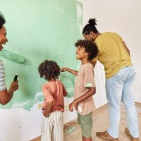 happy african american family talking while painting walls in their apartment. - home decoration stock pictures, royalty-free photos & images
