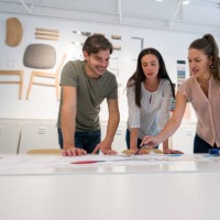 happy architect talking to her clients at the office and showing them a design for their house - home decoration stock pictures, royalty-free photos & images