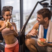 happy athletic couple eating healthy food on a break in a gym. - food stock pictures, royalty-free photos & images