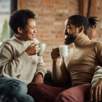 happy black couple talking during tea time at home. - coffee stockfoto's en -beelden