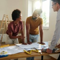 happy black couple talking while analyzing housing plan with an architect. - home decoration stock pictures, royalty-free photos & images