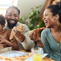 happy black family eating pizza for lunch in dining room. - junk food stock pictures, royalty-free photos & images