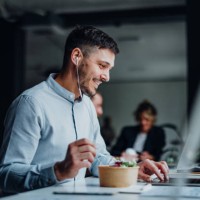 happy business man talking on a video call during a lunch break in a office - food stock pictures, royalty-free photos & images