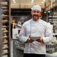 happy business owner managing a bakery and using a digital tablet - food stock pictures, royalty-free photos & images