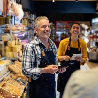 happy business owner talking to some employees at a supermarket - food stock pictures, royalty-free photos & images