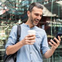 happy businessman looking at the smartphone in the city, berlin, germany - junk food stock pictures, royalty-free photos & images