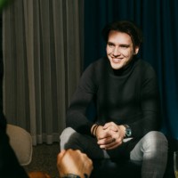 happy businessman with hands clasped talking to colleague during event at convention center - fashion stock pictures, royalty-free photos & images