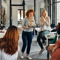 happy businesswoman serving takeaway food to colleagues in office - junk food stock pictures, royalty-free photos & images