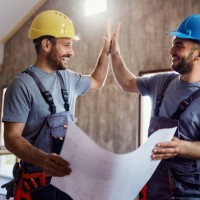 happy construction workers congratulating each other at renovating house. - home decoration stock pictures, royalty-free photos & images