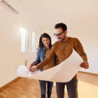 happy couple analyzing blueprints in their new apartment. - home decoration stock pictures, royalty-free photos & images