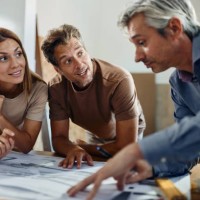 happy couple analyzing blueprints with an architect. - home decoration stock pictures, royalty-free photos & images
