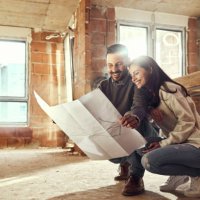 happy couple analyzing plans at their renovating apartment. - home decoration stock pictures, royalty-free photos & images