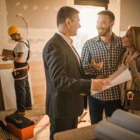 happy couple and building contractor talking about housing plan at construction site. - home decoration stock pictures, royalty-free photos & images