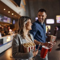 happy couple bought popcorn and drinks before movie projection in cinema. - food stockfoto's en -beelden