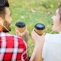 happy couple drinking coffee and listening music in the park - junk food stock pictures, royalty-free photos & images