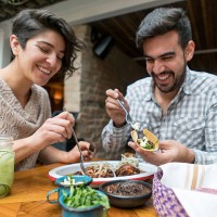 happy couple eating at a restaurant - food stock pictures, royalty-free photos & images